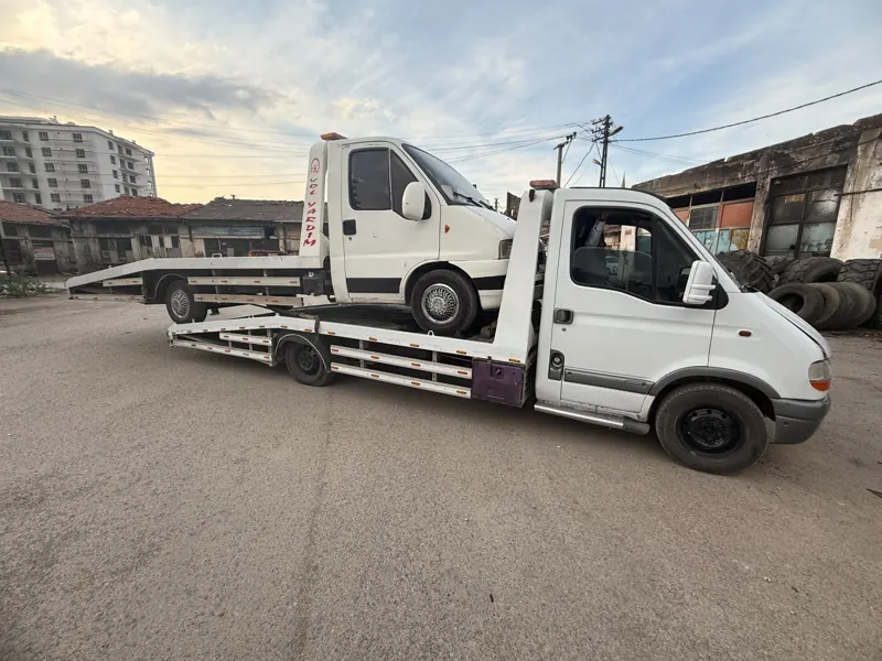 Çekici kasasında taşınan beyaz kamyonet